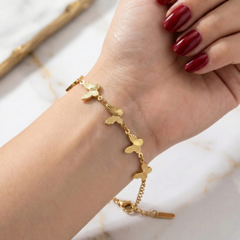 انسيال ذهبي مصنوع من الستانلس ستيل المقاوم للصدأ، مزين بفراشات بارزة بتفاصيل محفورة لامعة، تصميم رقيق يبرز جاذبية معصمك، مع قفل قابل للتعديل ليناسبك. - Image 2